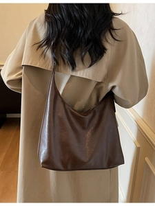Retro brown large capacity hobo shoulder bag shown on model in minimal interior