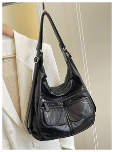 Close-up of black PU leather tote bag with dual front zipper pockets and texture