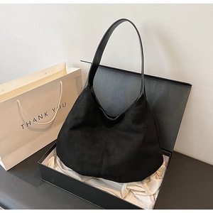Chic black suede hobo shoulder bag with leather strap in an elegant gift box setup