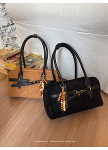 Detail of vintage suede Boston bags with leather handles and decorative wooden bead charms