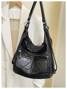 Detail of black pebbled leather multifunctional shoulder bag with silver hardware and pockets