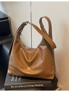 Retro brown leather hobo tote bag with adjustable strap on minimalist background