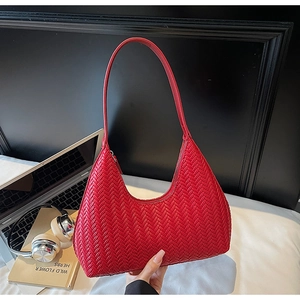 Dettaglio della borsa hobo in pelle intrecciata rossa su una scrivania ufficio