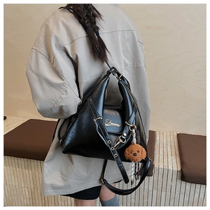 Détail du grand sac cabas en similicuir noir avec logo doré et breloque ourson