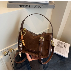 Détail du sac bandoulière vintage marron foncé avec pendentif en perles colorées