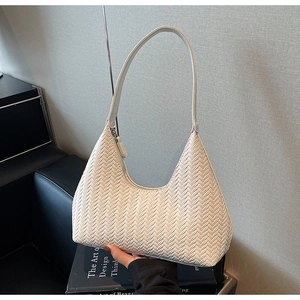 Dettaglio della borsa hobo intrecciata color crema con trama a V e morbida ecopelle di lusso