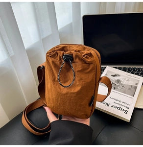 Detail of waterproof nylon crossbody bag with drawstring pocket and wide shoulder strap