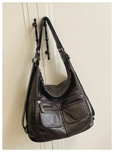 Detail of dark brown washed faux leather surface with vintage texture and silver zippers