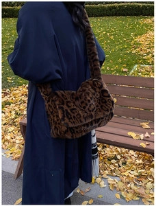 Dettaglio della borsa a spalla in peluche leopardata indossata in un parco autunnale