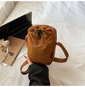 Brown nylon crossbody mobile phone bag detail with adjustable drawstring and woven label