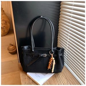 Detail of black matte suede tote bag featuring vintage wooden beads and silver buckle