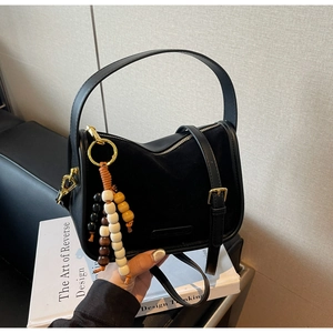 Détail du sac bandoulière noir mat avec perles en bois colorées et finitions en métal doré