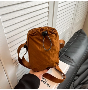 Detail of brown nylon crossbody phone bag with drawstring and adjustable strap