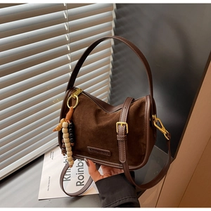 Détail du sac à main vintage en daim marron foncé avec pendentif en perles de bois