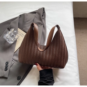 Dettaglio ravvicinato della borsa hobo intrecciata marrone scuro con manico liscio e zip