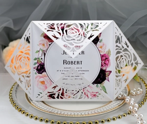 Macro view of laser-cut rose hollow invitation card on an elegant wedding decorative plate