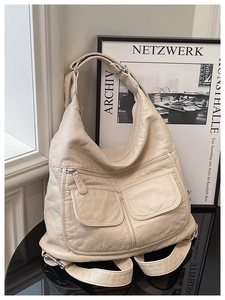Detail of off-white lychee texture leather bag with multi-pocket and convertible straps