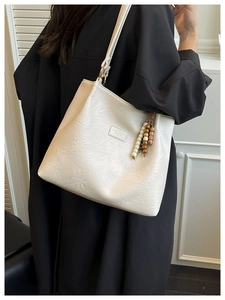 Creamy white oversized tote bag with wrinkled leather texture and bead tassel detail