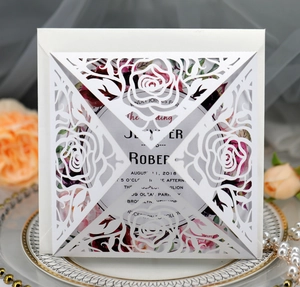 Detail of laser-cut rose wedding invitation set on an elegant decorative ceramic plate