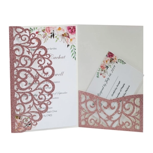 Dettaglio dell'invito di nozze glitter oro rosa con intricato motivo floreale tagliato a laser