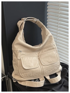 Detail of beige lychee texture leather handbag featuring multi-pocket functional design