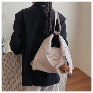 Détail du sac hobo crème sur le dos avec charm ours et détail de corde tressée