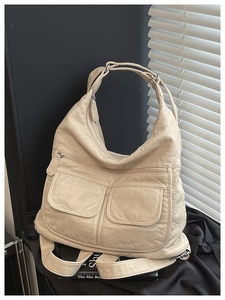 Detail of cream white large capacity shoulder bag with vintage pleated leather and silver buckles