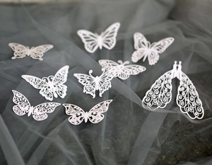 White laser cut paper butterflies and peacock decorations for elegant party decor