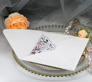 Detail of laser cut rose wedding invitation card with pink floral inner lining and envelope