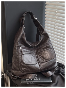 Detail of dark coffee vintage leather bag with double front pockets and wide strap