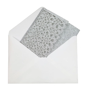 Close-up of glitter silver laser-cut floral wedding card with a matching white envelope
