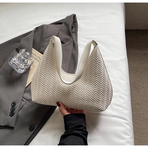 Dettaglio della trama intrecciata bianca di una borsa sottobraccio chic e minimalista