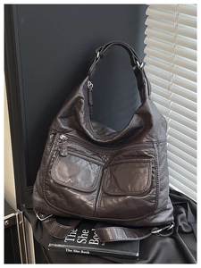 Macro shot of dark brown pebbled leather texture and multi-pocket design on the bag