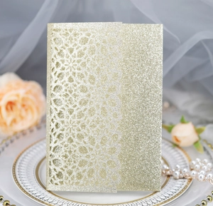 Detail of laser-cut glitter gold wedding invitation with elegant floral lace patterns