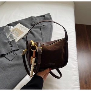 Détail du sac rétro marron en cuir brossé avec perles en bois et fermeture dorée