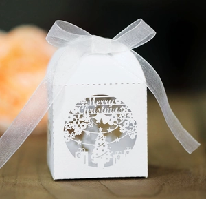 Detail of laser cut Merry Christmas hollow pattern and white ribbon on paper gift box