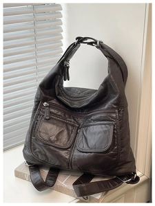 Detail of dark brown lychee leather bag texture with functional double front pockets