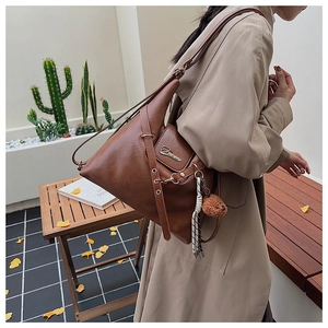 Sac fourre-tout vintage en cuir marron avec breloque d'ours en peluche sur l'épaule
