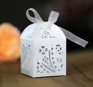 Close-up of laser-cut floral pattern on white gift box with elegant organza ribbon