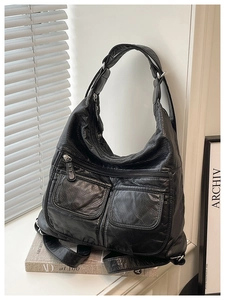 Detail view of the multi-pocket retro black crossbody bag with soft washed leather texture