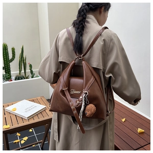 Détail du sac cabas vintage en cuir PU marron avec breloque ours dans un décor d'intérieur
