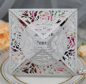 Silver glitter laser-cut wedding invitation cover with intricate rose pattern detail