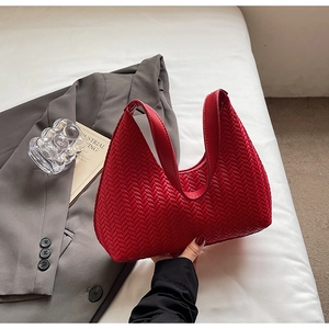 Dettaglio della borsa hobo rossa con trama a V intrecciata e manico elegante