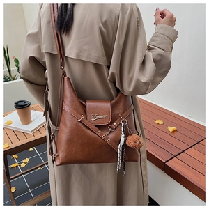 Sac cabas vintage marron avec boucle logo en métal et pendentif ours en peluche sur la sangle