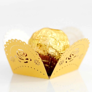 Close-up of golden laser-cut chocolate wrapper with elegant rose patterns and lace edges