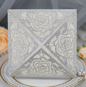 Macro shot of silver glitter laser-cut rose hollow invitation sleeve for weddings