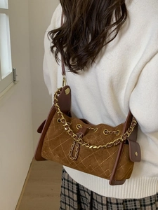 Sac bandoulière matelassé marron rétro avec chaîne dorée porté par un mannequin