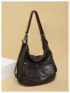 Detail of soft litchi grain coffee brown leather bag with functional silver zippers