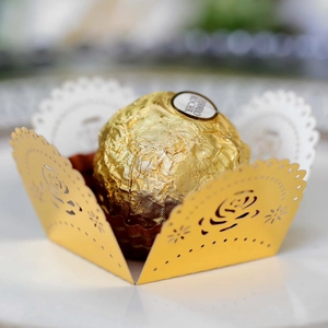 Macro detail of laser-cut rose pattern on golden lace chocolate wrapper for weddings
