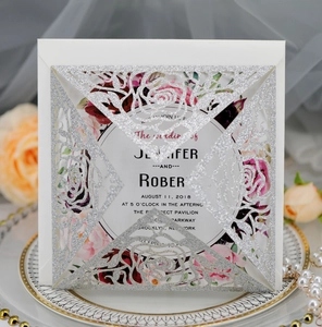 Detailed silver glitter laser-cut floral wedding invitation on elegant satin background